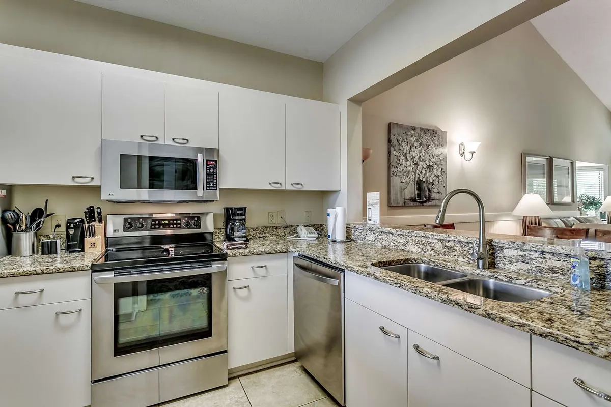 A modern, fully equipped kitchen with stainless steel appliances, granite countertops, and an open layout that connects to the living area. The kitchen is bright and spacious, ideal for cooking together or entertaining guests.