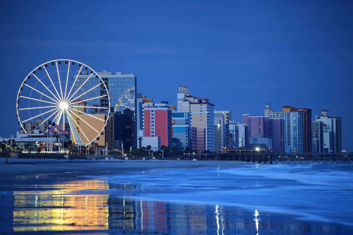 The image captures a Ferris wheel along the water, colorful buildings, and ocean reflections. Activities include amusement rides, beach walks, and nighttime sightseeing, set in a festive and adventurous mood.